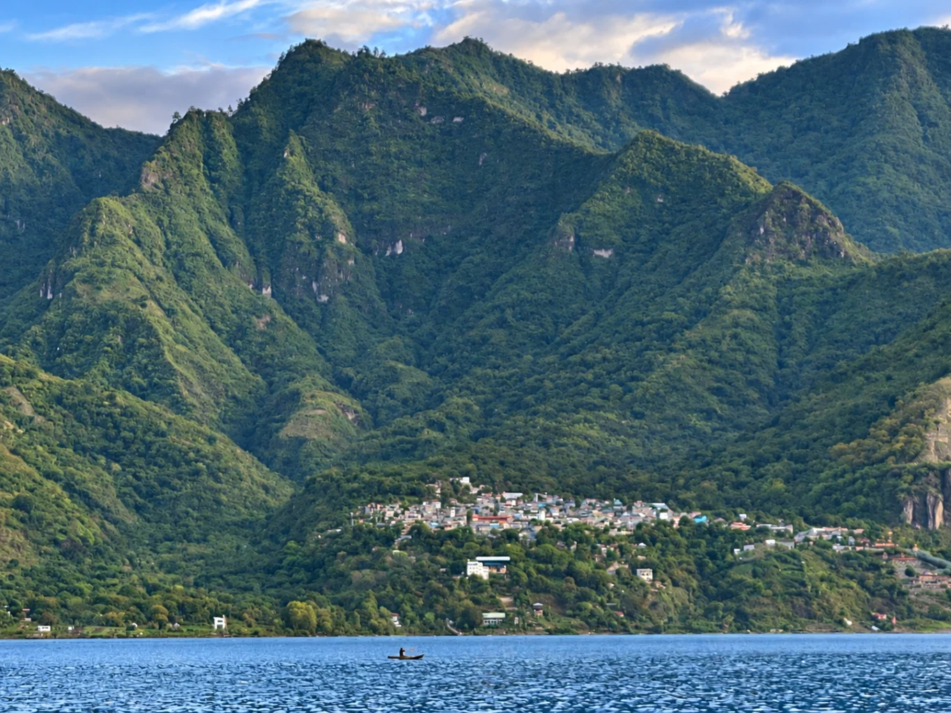 Sololá Lake Atitlan Southwest Guatemala 2021. A fisherman on a small boat in the vast Lake Atitlan overlooking the capital Solola where he'll sell the fish in market city. Credit Celena Brown 2021